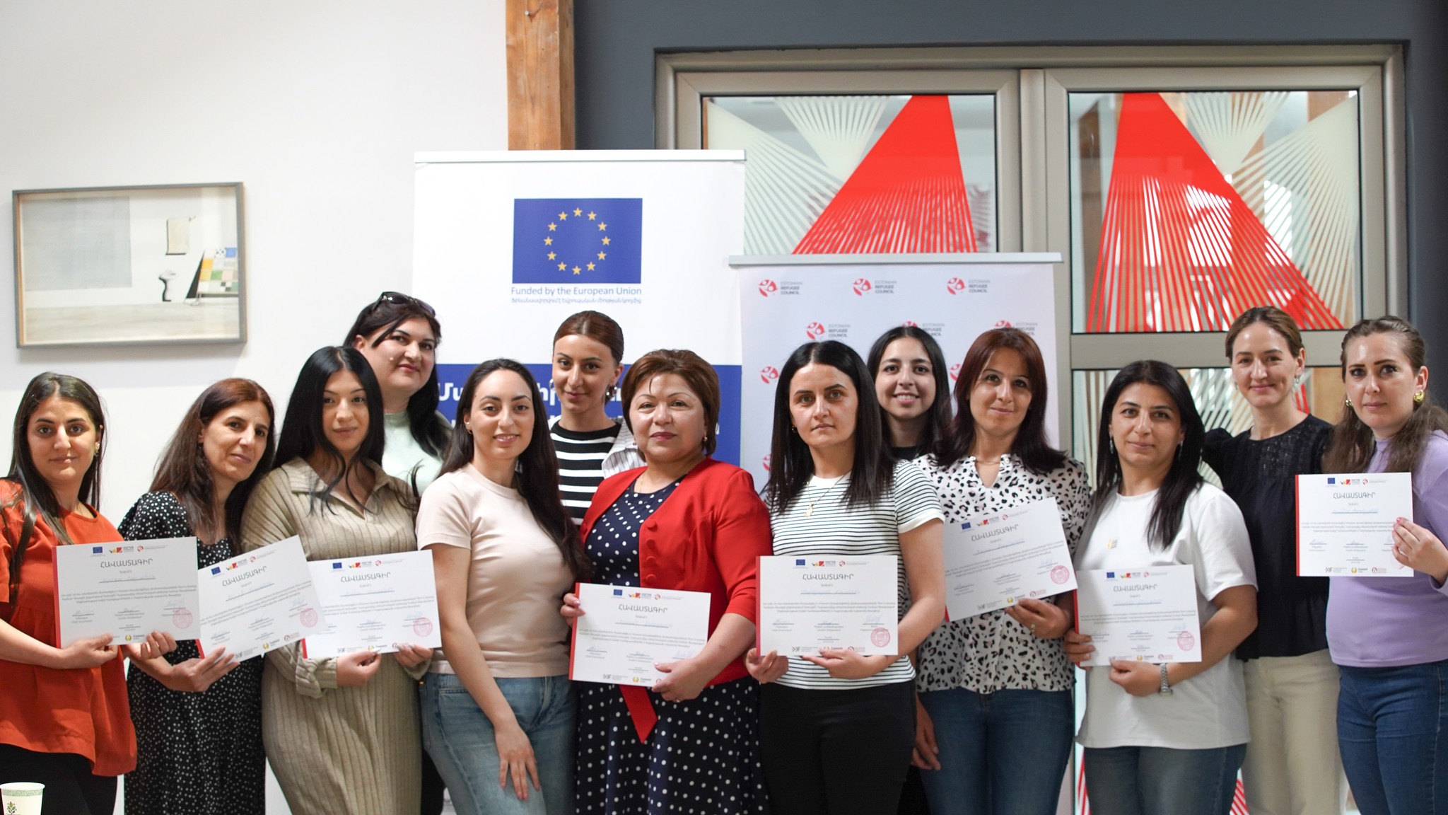 People standing with diplomas 