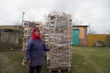 Woman standing with logs 